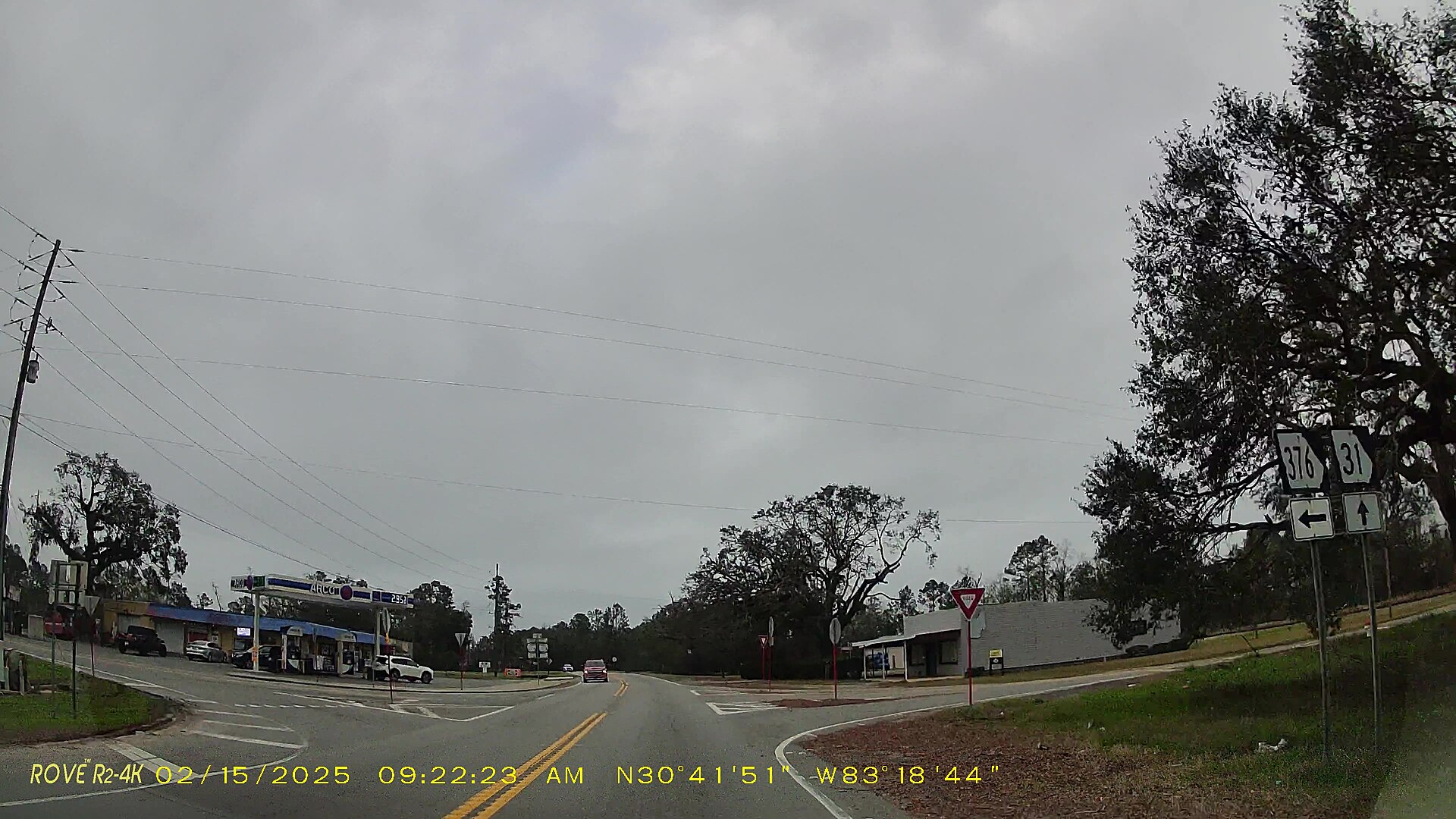 Dashcam view of a highway junction with a green directional road sign